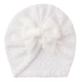 Detailed view of soft waffle knit texture on baby turban hat with large bow decoration - White