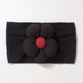 Detailed view of baby headband featuring a large black flower with red plaid button center - Black