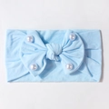 Dettaglio della fascia per neonati celeste con grande fiocco e perle bianche eleganti - Blu
