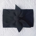 Detail view of a soft black nylon baby headband with a large decorative bow - Black