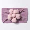 Detail of lavender knit baby headband with pink polka dot flower and cable stitch patterns - Taro Purple