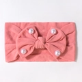 Dettaglio della fascia rosa per neonati con fiocco grande e perle bianche su tessuto - Malva Scuro