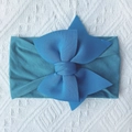 Detailed close-up of navy blue nylon baby headband with a soft double bow on a white blanket - Navy Blue