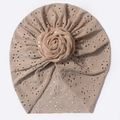 Détail d'un turban bébé tricoté ajouré avec rose en tissu à paillettes et motif respirant - Café