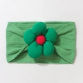 Detail of baby grass green knitted headband with large 3D floral accent on white background - Green