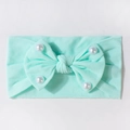 Dettaglio fascia neonata verde menta con grande fiocco e perle bianche in morbida maglia - Verde menta
