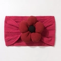 Close-up of deep magenta knitted baby headband with a large ribbed flower and button - Burgundy