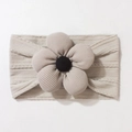 Close-up of baby knitted headband with a large 3D floral accent in soft beige color - Gray