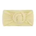 Close-up of a soft pale yellow nylon baby headband featuring a knit donut knot design - Beige