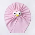 Close-up of pink baby turban with cartoon eyes and soft ribbed knit texture detail - Pink