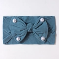 Dettaglio fascia neonato in maglia blu pavone con fiocco e perle decorative - Blu Notte