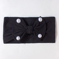 Dettaglio della fascia nera per neonati con grande fiocco e quattro perle bianche decorative - Nero