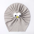 Détail du bonnet turban pour bébé montrant la maille côtelée et les yeux en peluche - Gris