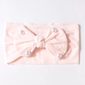 Detailed texture of pink baby headband featuring a large bow and white pearls - Light Pink