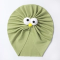 Détail d'un turban bébé en tricot côtelé vert herbe avec d'adorables yeux de dessin animé - Vert