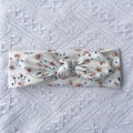 Détail d'un bandeau bébé en maille côtelée à fleurs avec nœud sur fond de dentelle blanche - Beige Floral Orange (E)