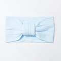 Detail of baby headband featuring light blue cable knit pattern and large center knot - Blue