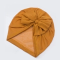 Nahaufnahme des senfgelben Baby-Turban-Huts aus Mesh mit großer Schleife und feinen Nähten - Erdgelb