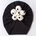 Detailed view of black breathable baby turban hat with white polka dot flower detail - Black