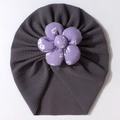 Detail of baby turban hat showing ribbed grey fabric and purple floral decoration - Gray
