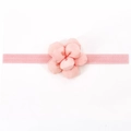 Détail d'un bandeau bébé rose élastique avec une fleur en tissu faite à la main - Bourgeon de Neige