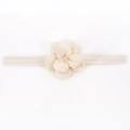 Gros plan d'un bandeau extensible pour bébé avec une fleur en tissu rose multicouche - Beige