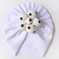 Close-up of baby turban hat with a white waffle fabric and a large black polka dot flower - White