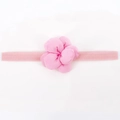 Détail d'un bandeau pour bébé avec bande rose élastique et fleur en tissu 3D souple - Rose