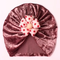 Detailed close-up of velvet baby hat featuring a 3D red polka dot floral decoration - Dusty Pink
