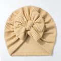 Close-up of baby beanie with a large bow and ribbed knit texture in beige color - Coffee