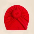 Detail einer roten Baby-Turbanmütze aus weichem Strick mit dekorativem Donut-Knoten - Rot
