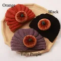 Detailed knit texture of orange, black and purple baby pumpkin hats on a tray - Mixed Colors