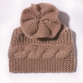 Detalle de gorro de punto marrón para bebé con trenzado y adorno de flor - café