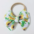 Dettaglio della fascia per neonati con stampe di girasoli e fiocco testurizzato - Stile Stampa Girasole / Giallo ocra