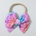 Close-up of baby headband featuring a waffle fabric bow with rainbow fish scale patterns - Colorful Fish Scale Print Style / Purple