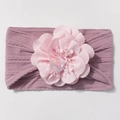 Detail van een baby haarband met een grote lichtroze kunstbloem op paars gebreide stof - Taropaars