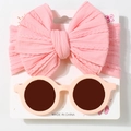 Close-up of pink bow headband and round sunglasses set on display card for baby girls - Pink
