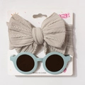 Macro detail of beige knit bow headband and light blue round sunglasses on summer display card - Gray