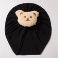 Detail of baby knot turban hat in black soft knit cotton with a beige plush bear patch - Black