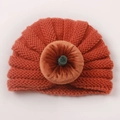 Detail van de oranje gebreide pompoen babytulband met fluwelen knoop en groene steel - Oranje