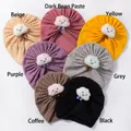 Flat lay of baby waffle knit turban hats in seven colors with plush smiling cloud detail - Multicolor