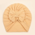 Detailansicht der Waffelstruktur und großen Schleife an der weichen Baby-Turbanmütze - Beige