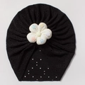Close-up of black breathable eyelet fabric baby turban with a white floral ornament - Black