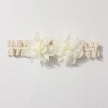 Close-up of baby lace headband with 3D chiffon flowers and elastic crochet details - Beige
