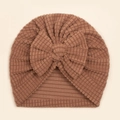 Détail de la texture gaufre et du grand nœud sur ce turban marron pour bébé - Café