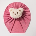 Detail of baby beanie featuring a white sherpa bear patch on pink knit fabric - Dusky Pink