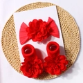 Flat lay of red floral baby headband and matching socks set on a rustic woven mat - Red
