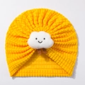 Detail einer gelben Baby-Beanie aus Waffelstrick mit aufgenähter lächelnder Wolke - Gelb