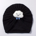 Detailed close-up of a black knit baby turban hat with a smiling white cloud decoration - Black
