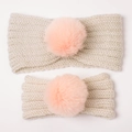 Detail van gebreide haarbanden voor moeder en kind met zachte pompons in gebroken wit - Beige